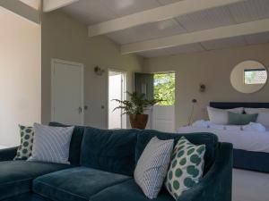 a living room with a blue couch and a bed at Horseshoe Barn in Axminster