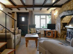 a living room with a couch and a fireplace at Hill View Cottage in Snowshill