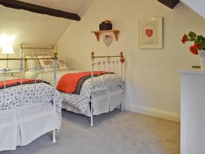 a bedroom with two twin beds in a room at Hill View Cottage in Snowshill