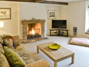 a living room with a couch and a fireplace at Chapel Cottage in Sharrington
