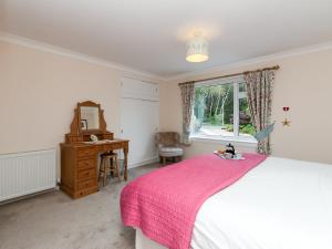 a bedroom with a bed and a desk and a window at Sheeoch in Comrie