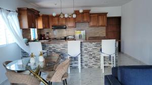 a kitchen with a glass table and chairs at Madome Aparta Hotel in Pedernales