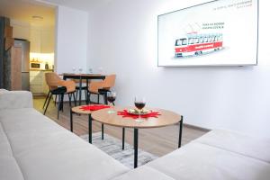 una sala de estar con 2 mesas y un autobús rojo en la pared en Apartman Ravna Planina, en Pale