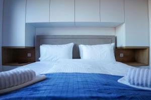 1 cama grande con sábanas azules y almohadas blancas en Apartman Ravna Planina, en Pale