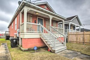 a red house with a white porch and a wooden fence at Pet-Friendly Home Less Than 3 Mi to French Quarter! in New Orleans