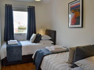 1 dormitorio con 2 camas y ventana en Sandy View, en Beadnell