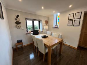 a dining room with a wooden table and chairs at 3 Bed Detached Cottage- Log Burner Mountain Views in Beaumaris