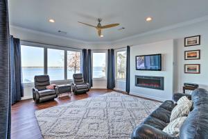 ein Wohnzimmer mit einem Sofa, Stühlen und einem TV in der Unterkunft Beautiful Waterfront Getaway with Dock! in Abbeville