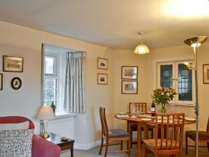 een woonkamer met een tafel en stoelen en een eetkamer bij Edenwoodend Cottage in Kilmaron
