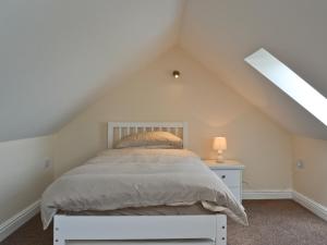a bedroom with a white bed in the attic at The Willows in Toynton All Saints