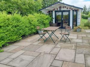 a patio with a table and chairs and a gazebo at The Willows in Toynton All Saints