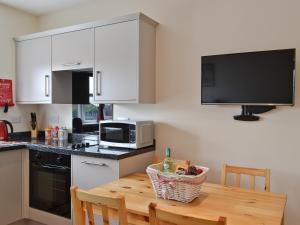 a kitchen with a wooden table and a microwave at The Willows in Toynton All Saints