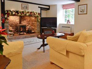 a living room with a fireplace and two chairs at Karslake House in Winsford