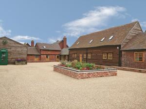 a group of buildings with flowers in a courtyard at Shippon Cottage - E4299a in Halston