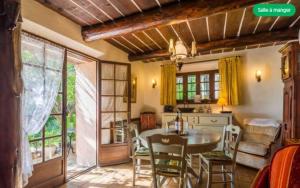Una cocina y un comedor con mesa y sillas. en Le mas du goio, en Seillans