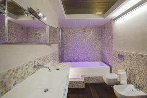 a purple bathroom with a tub and a sink and a toilet at Palazzo Carletti in Montepulciano