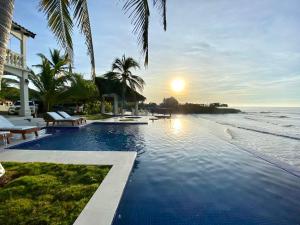 a swimming pool with a view of the ocean at Vista Las Olas Resort in El Cuco