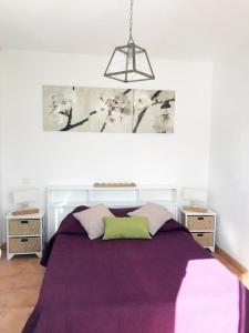a bedroom with a purple bed with two night stands at La bastide neuve - le cabanon in La Môle