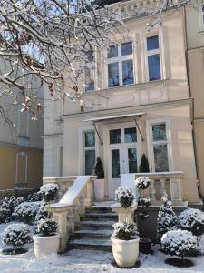 a white house with snow on the stairs at Suites La Bella in Sopot