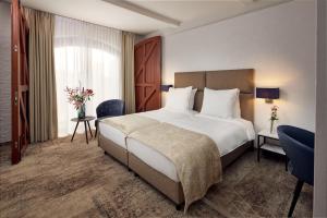a hotel room with a large bed and a window at Van der Valk Hotel Mechelen in Mechelen