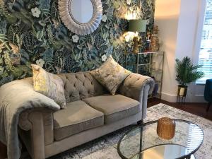 a living room with a couch and a table at The Cheltenham, stylish 1-bed Victorian apartment in Harrogate