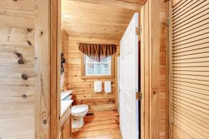 a wooden bathroom with a toilet and a window at Victorian Secret in Sautee Nacoochee