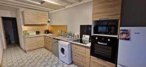 a kitchen with a washing machine and a refrigerator at Le Viking entre mer et terre in Vaux-sur-Aure