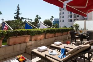 a patio with tables and chairs on a balcony at Hôtel Barrière Le Majestic Cannes in Cannes