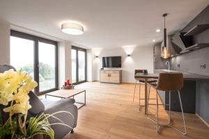 een woonkamer met een bank en een tafel bij Chalet-Ferienwohnung Schlossblick, 51 qm, Wellness/Fitness/Sauna – Bergrödelhof in Feilitzsch