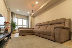 - un salon avec un grand canapé brun dans l'établissement Orzan Beach by Urban Flats, à La Corogne