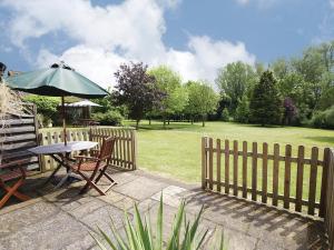 a table with an umbrella next to a fence at Lindas Lodge in Holton