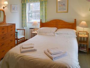 a bedroom with a bed with towels on it at The Stables in Dunterton