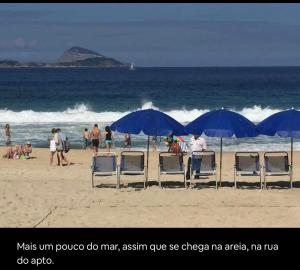 un grupo de personas en una playa con sillas y sombrillas en Apartamento Leblon João lira quadra da praia - melhor do Leblon, en Río de Janeiro