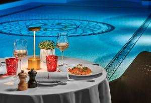 a table with a plate of food and glasses of wine at Hôtel Barrière Le Majestic Cannes in Cannes