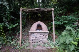 a stone oven in the middle of a garden at Luxury Cottage near Hay-on-Wye in Llanigon