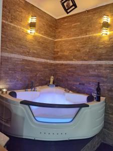 a bath tub in a room with a brick wall at President spa apartman Arandjelovac in Arandjelovac