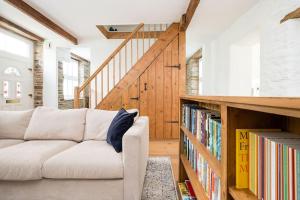ein Wohnzimmer mit einem Sofa und einem Bücherregal mit Büchern in der Unterkunft Luxury Cottage near Hay-on-Wye in Llanigon