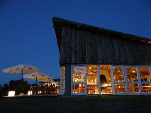 a building with tables and umbrellas at night at Villa Serrana - Mesón de las cañas in Villa Serrana