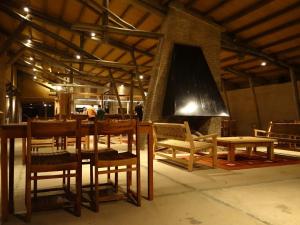 Habitación con mesa, sillas y chimenea. en Villa Serrana - Mesón de las cañas, en Villa Serrana