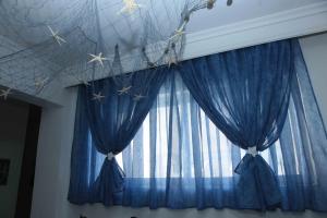 a room with a window with blue curtains and stars at Hellas Dream in Perea