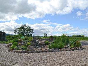 ogród z kamieniami i roślinami na żwirowej drodze w obiekcie Mill Cottage w mieście Ravensworth