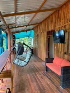 a porch with a hammock and a couch at Bahías Lodge in Rincón