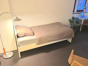 ゲルゼンキルヒェンにあるApartment in Gelsenkirchenのベッドルーム(ベッド1台、ランプ、デスク付) +3枚の写真