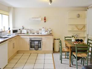 uma cozinha com uma mesa e uma cozinha com um fogão em The Old Mill em Bampton