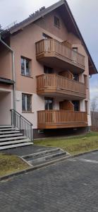 - un bâtiment avec des balcons en bois sur le côté dans l'établissement Jagoda 11, à Karpacz
