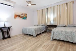 - une chambre avec 2 lits et un ventilateur de plafond dans l'établissement Sea Eye Hotel - Laguna Building, à Utila