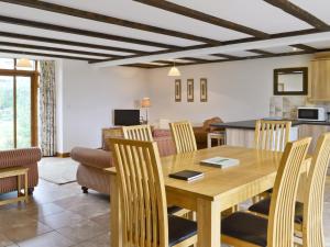 a dining room and living room with a wooden table and chairs at Mint - E4322 in Ludham