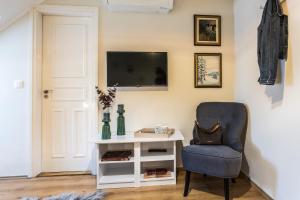 Habitación con escritorio, silla y TV. en Kikerics vendégház, en Villány