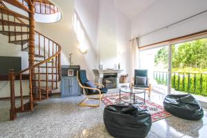 a living room with a staircase and a fireplace at Private Gardened House - 5min from the beach in Viana do Castelo
