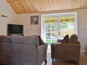 a living room with two couches and a television at Bowles Cottage in Lechlade